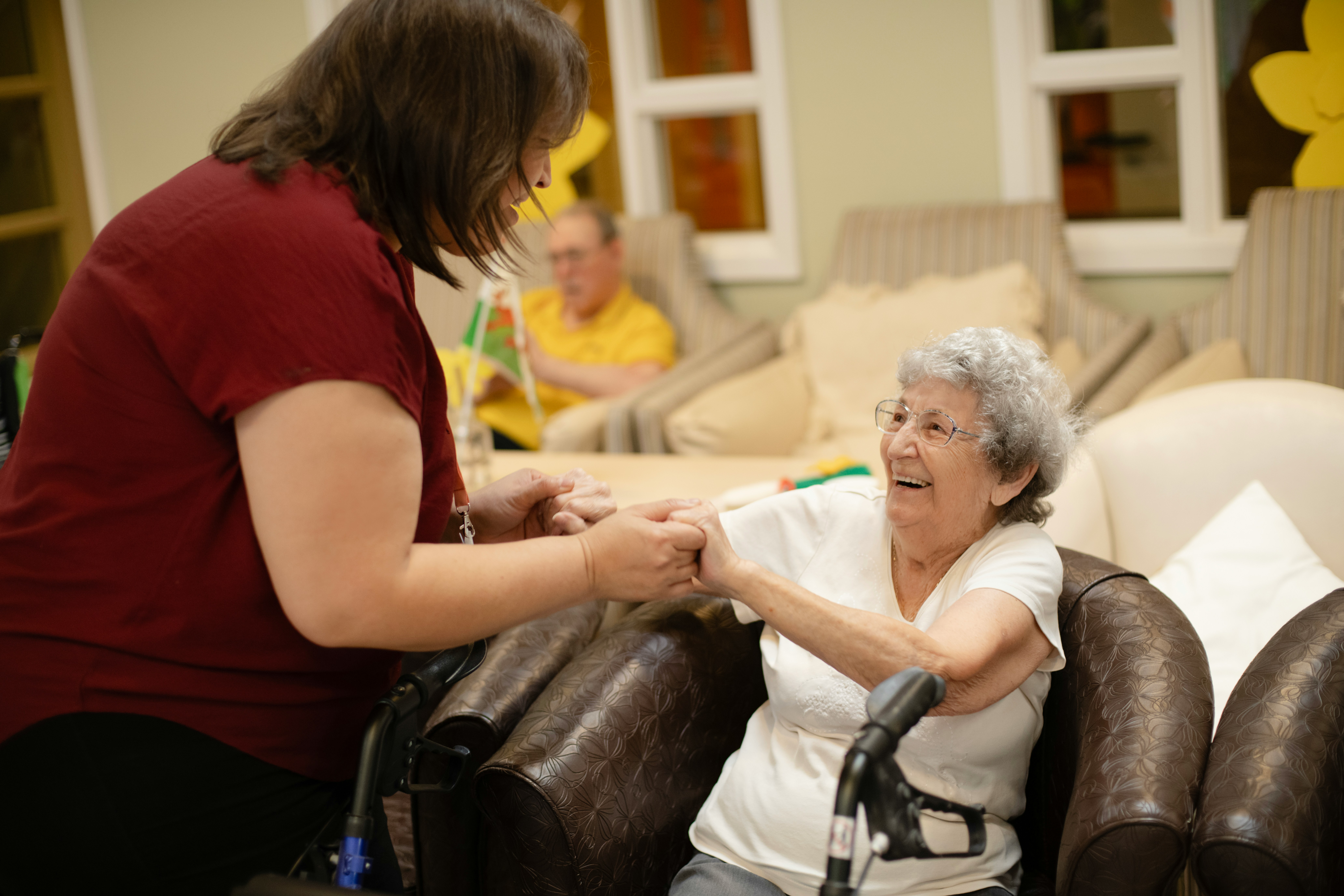 Caregiver holding hands with senior adult at home